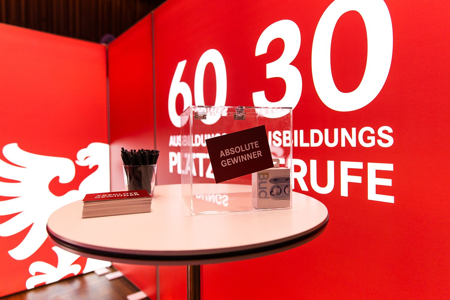 Stehtisch mit einer Losbox, Postkarten und Kugelschreibern am Messestand der Stadt Reutlingen