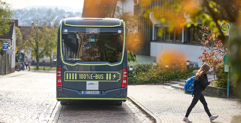 E-Bus des RSV Reutlingen von hinten an einer Haltstelle mit einem Kind